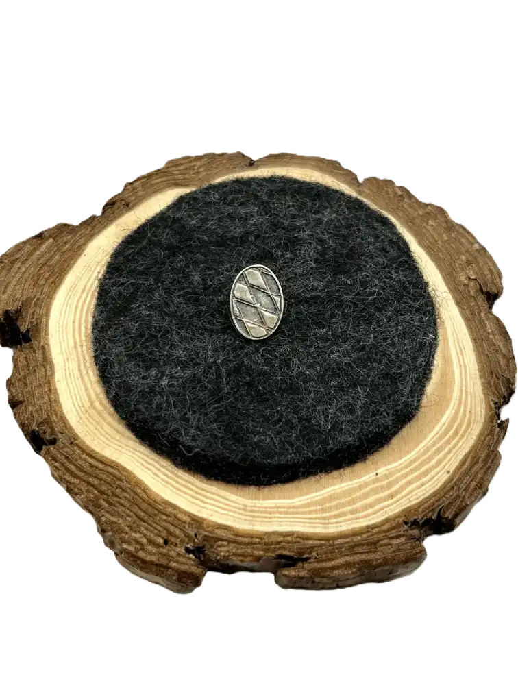 Das Bayerische Wappen auf der Brust mit dem Heimatliebe Bayern Anstecker